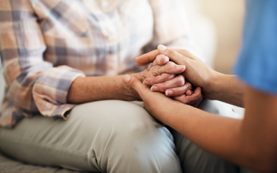 iStock image of a nurse holding a patient's hands for comfort | Icon Cancer Centre